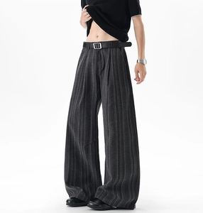 Detail of dark striped wide-leg trousers with leather belt and silver square buckle