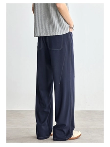 Dettaglio dei pantaloni larghi blu scuro da uomo con cuciture a contrasto e tasche retro