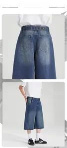 Detailed view of dark blue washed denim shorts featuring back pocket decorative stitching
