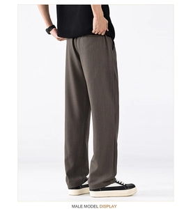 Vue détaillée montrant la texture drapée et la coupe du pantalon décontracté marron foncé