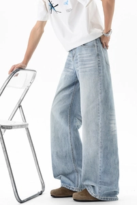 Detail shot of vintage washed light blue wide-leg jeans with natural cat whiskers texture