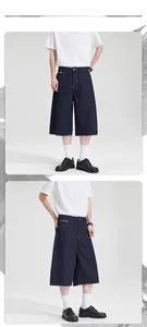 Detailed view of dark blue wide-leg denim shorts with side zipper pockets and clean-fit style