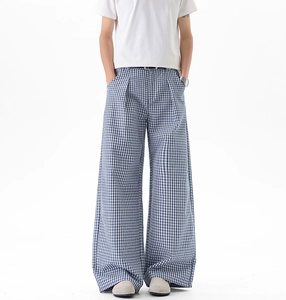Détails d'un pantalon homme à carreaux bleus et blancs avec une coupe large décontractée