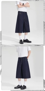 Detail of dark blue wide-leg denim shorts with yellow contrast stitching and stiff fabric