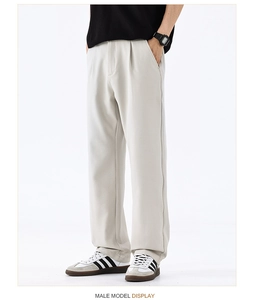 Détail du pantalon large gris clair avec plis avant et tissu en soie glacée drapé