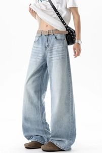 Detail of light blue washed denim jeans with vintage whiskering and wide leg fit for men