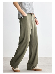 Dettaglio dei pantaloni larghi verde oliva con trama verticale e tessuto di cotone