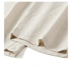 Detailed close-up of the hem stitching and textured Lyocell fabric on casual trousers