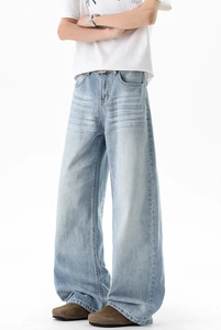 Close-up of light blue wide-leg jeans featuring heavy wash and cat-whisker whiskering
