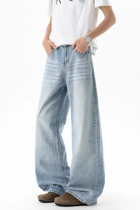Detail of light blue wide-leg jeans featuring heavy washing and cat-whisker whiskers