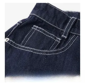 Vue macro de la poche avant en denim bleu avec surpiqûres blanches et rivets métalliques
