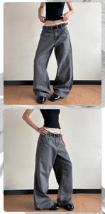 Detail of stone-washed khaki wide-leg jeans with black belt and layered waist design