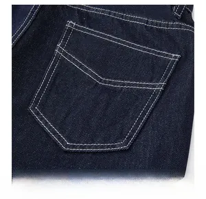 Détail de la poche arrière en denim bleu foncé avec double couture contrastée