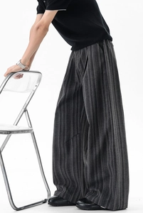 Detail of dark gray striped wide-leg pants with elegant drape and relaxed fit