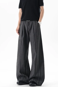 Detail of grey striped wide-leg pants showing premium fabric texture and pleated waist