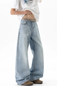 Detailed close-up of light blue vintage washed denim jeans with cat-whisker texture