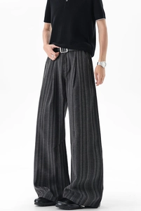 Detail shot of men's charcoal grey striped wide-leg trousers with premium draped fabric