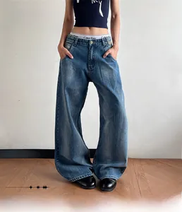 Detail of dark blue straight wide-leg jeans with vintage wash and whiskers effect