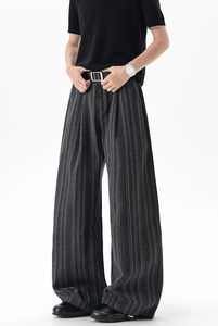 Detail of dark grey striped wide-leg pants with pleated front and smooth drape texture