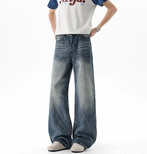 Close-up of vintage blue washed denim with whiskering effect and wide leg fit