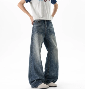 Close-up of vintage wash details and distressed cat whisker textures on wide-leg jeans