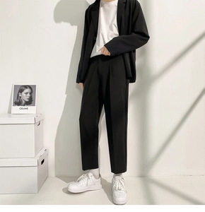 Détail d'un pantalon de costume noir coupe droite pour homme avec baskets blanches