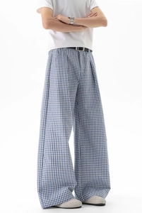 Détail d'un pantalon large à carreaux bleus avec taille haute et coupe droite ample