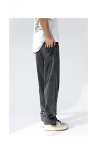 Detail view of baggy dark grey washed denim jeans showing vintage texture and loose fit cut