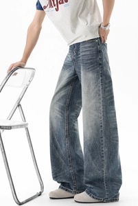 Detail view of retro washed blue wide-leg jeans with vintage whiskering and straight cut