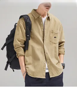 Detail of khaki twill cotton shirt showing the chest pocket and black letter embroidery