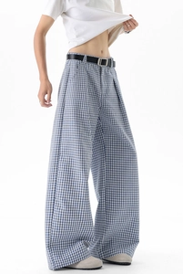 Détail du pantalon large à carreaux bleus et blancs avec ceinture à boucle noire