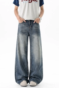Detailed view of dark blue wide-leg jeans featuring vintage washed whiskers and loose fit