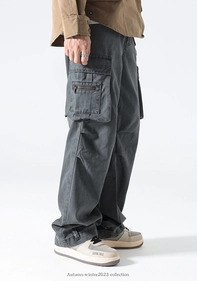 Detail view of multi-pocket cargo pants in dark grey with functional side flap pockets