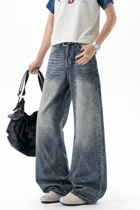 Detail of vintage washed blue wide-leg denim jeans showing high-quality fabric texture