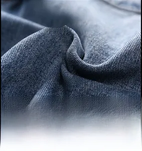 Macro shot of breathable blue denim fabric with twill texture and stitching on jeans