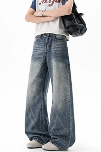 Detail of vintage washed wide-leg jeans with whiskering effects in American street style