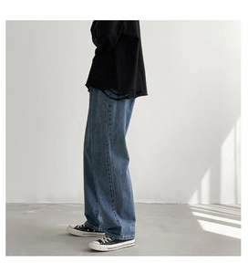 Detailweergave van baggy mid-blue gewassen jeans met rechte snit en natuurlijke stapeling