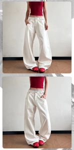 Detail view of high-waist white wide-leg denim jeans showing fabric texture and straight fit