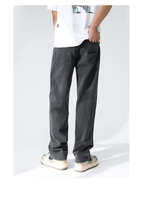 Detailed view of washed black denim straight-leg jeans with soft vintage drape texture