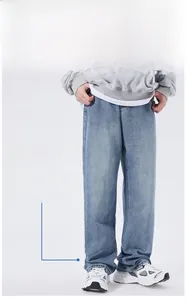 Detail view of light blue washed denim jeans featuring a loose straight leg and casual fit