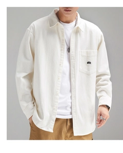 Detail of white cotton shirt featuring a chest pocket with MORAIA black embroidery