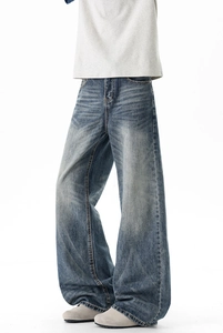 Close-up of vintage blue wash denim jeans with faded whiskering and relaxed straight fit