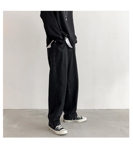 Zijaanzicht van de losse zwarte herenjeans met een ontspannen recht silhouet