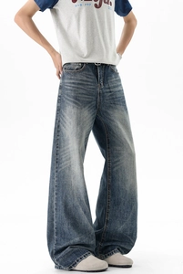 Detail of vintage wide-leg jeans with whiskered distressing and deep blue wash finish