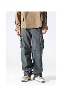 Detail of charcoal grey cargo pants with large functional flap pockets in street style