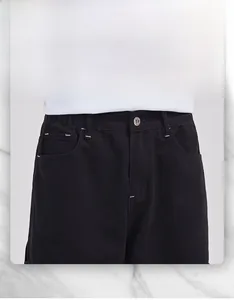 Détail du textile haute densité avec boutons métalliques sur un jean cargo noir droit