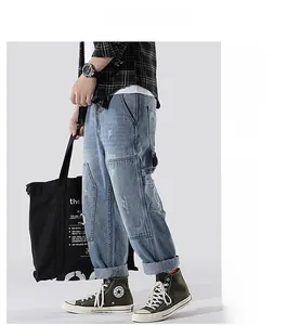 Detail of light blue distressed denim jeans with patchwork and side cargo pocket design