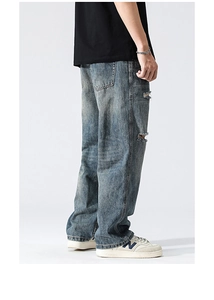 Détail d'un jean bleu délavé vintage avec des déchirures et un effet usé élégant