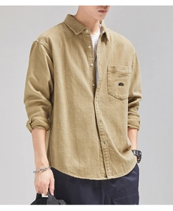 Close-up of khaki corduroy shirt pocket featuring detailed MOBALA black embroidery