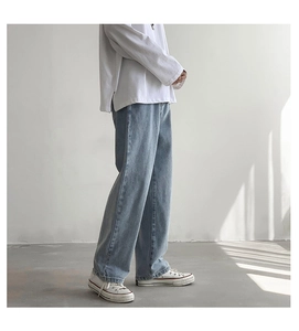 Zijaanzicht van wijde herenjeans in een lichtblauwe wassing met een relaxte pasvorm